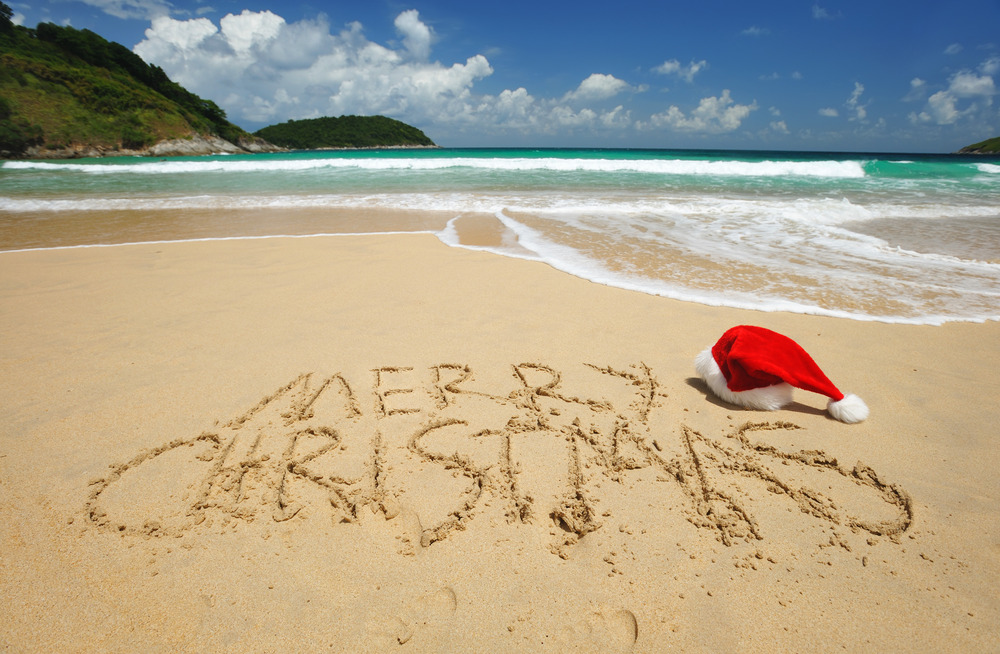 merry christmas written in the sand on the beach