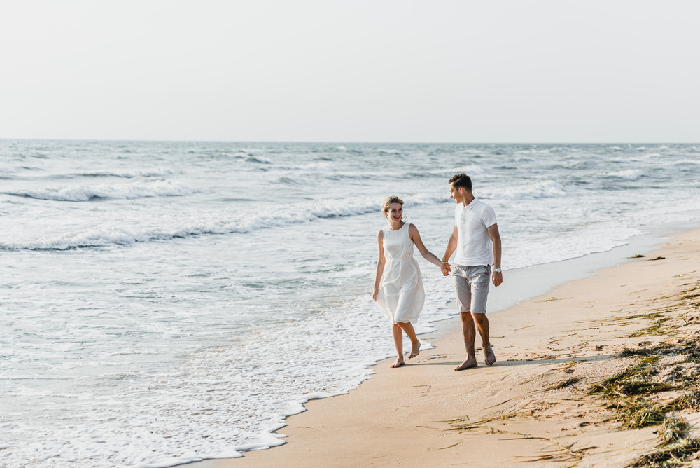 Couple walking on beach.